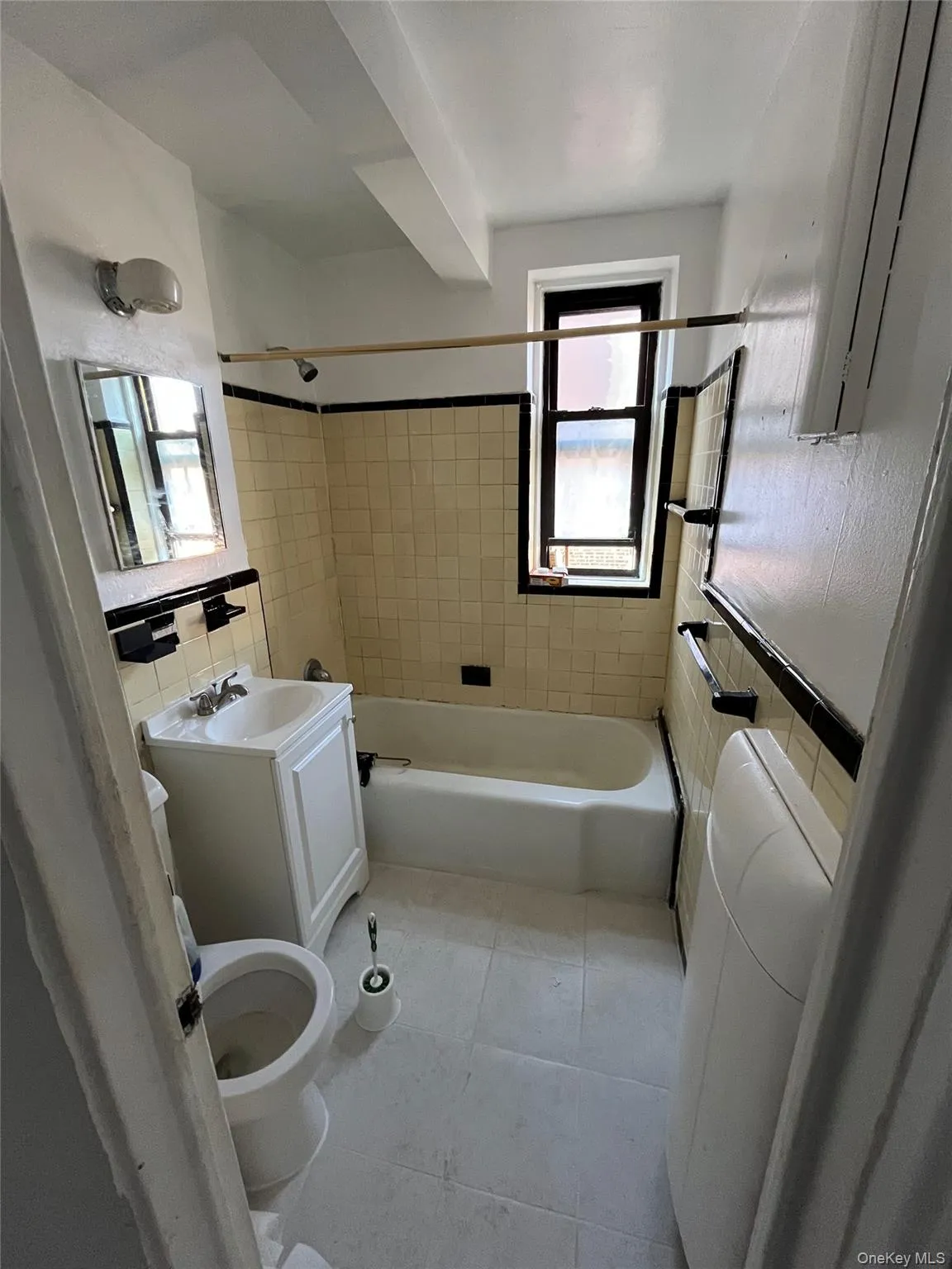 Bathroom with tile walls, shower / bathtub combination, vanity, and light tile patterned flooring Bathroom with tile walls, shower / bathtub combination, vanity, and light tile patterned flooring