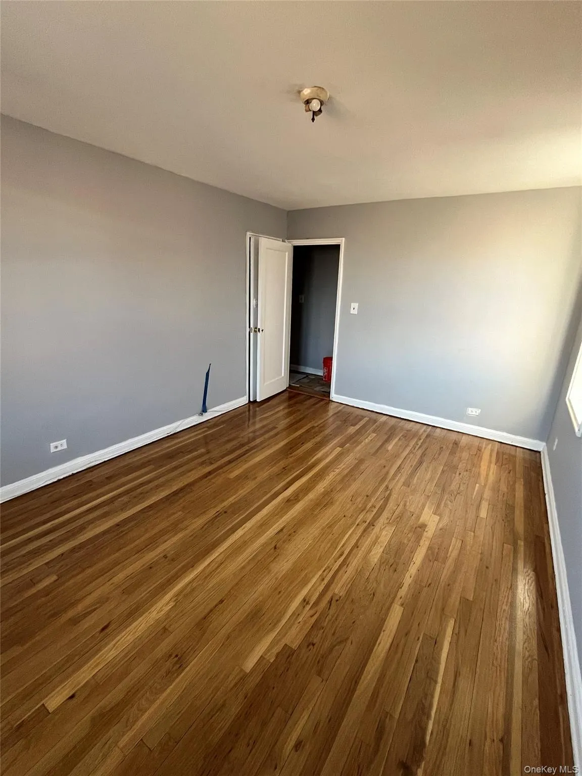 Spare room with baseboards and wood-type flooring Spare room with baseboards and wood-type flooring