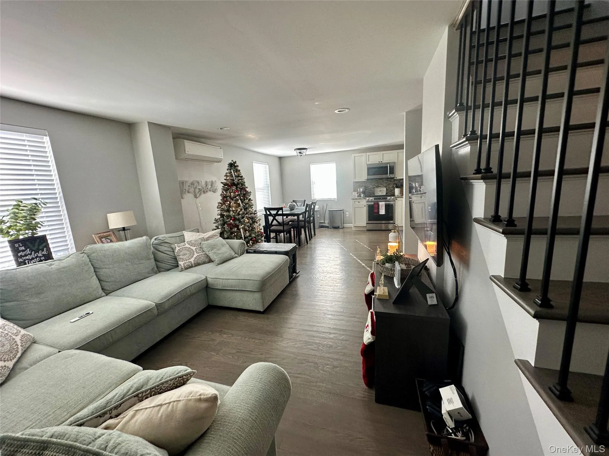 Living area featuring dark wood-style floors and a wall mounted AC Living area featuring dark wood-style floors and a wall mounted AC