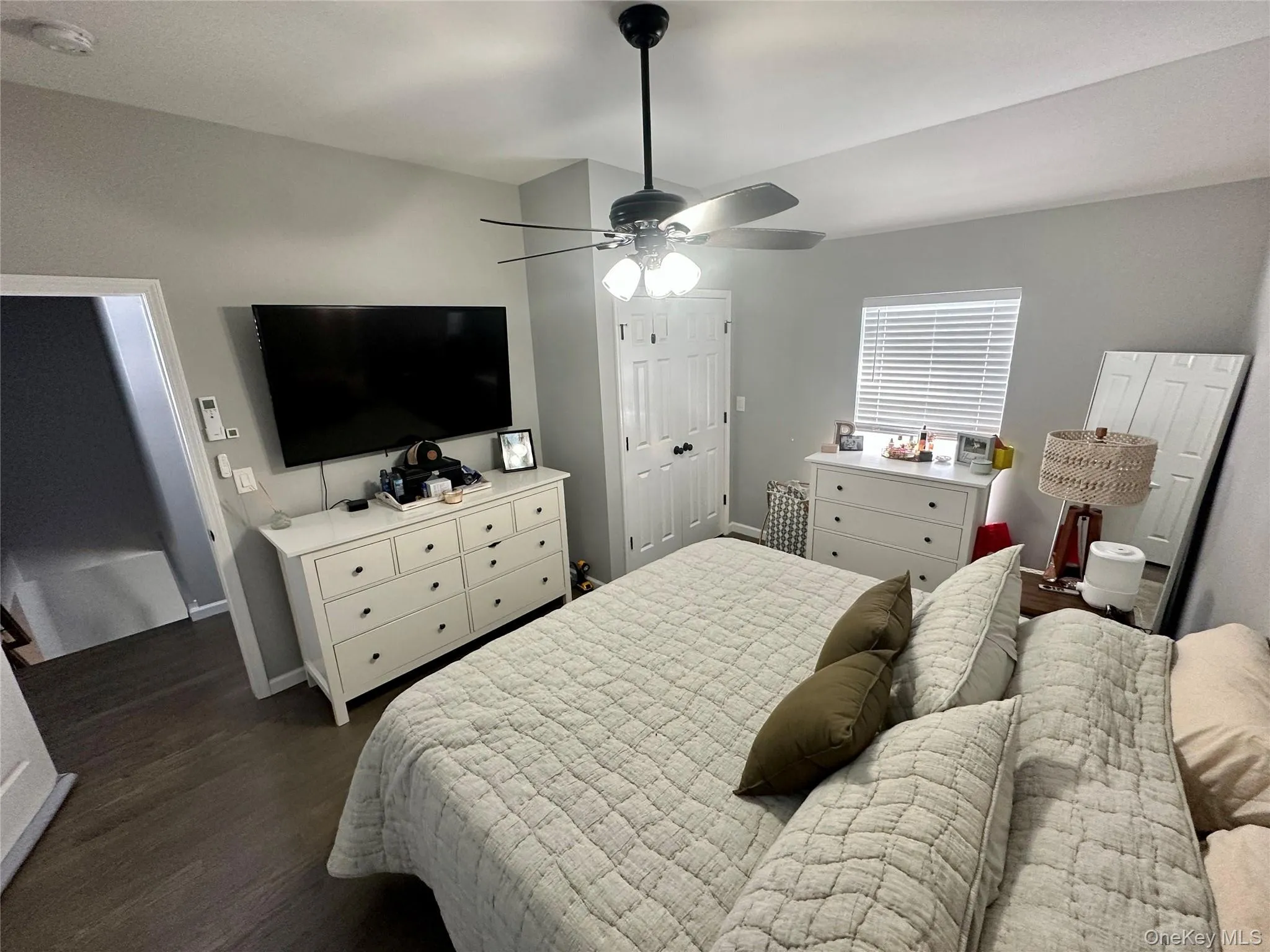 Bedroom with dark wood-style flooring, a ceiling fan, and a closet Bedroom with dark wood-style flooring, a ceiling fan, and a closet