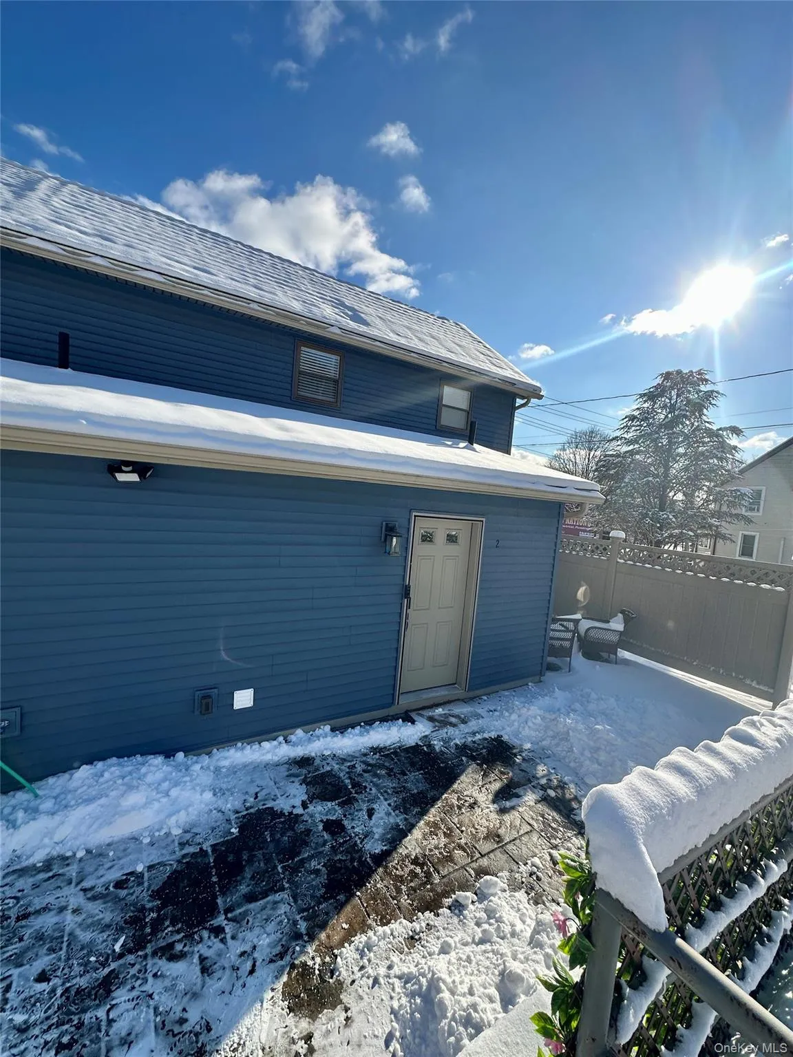 Snow covered property entrance featuring roof with shingles Snow covered property entrance featuring roof with shingles