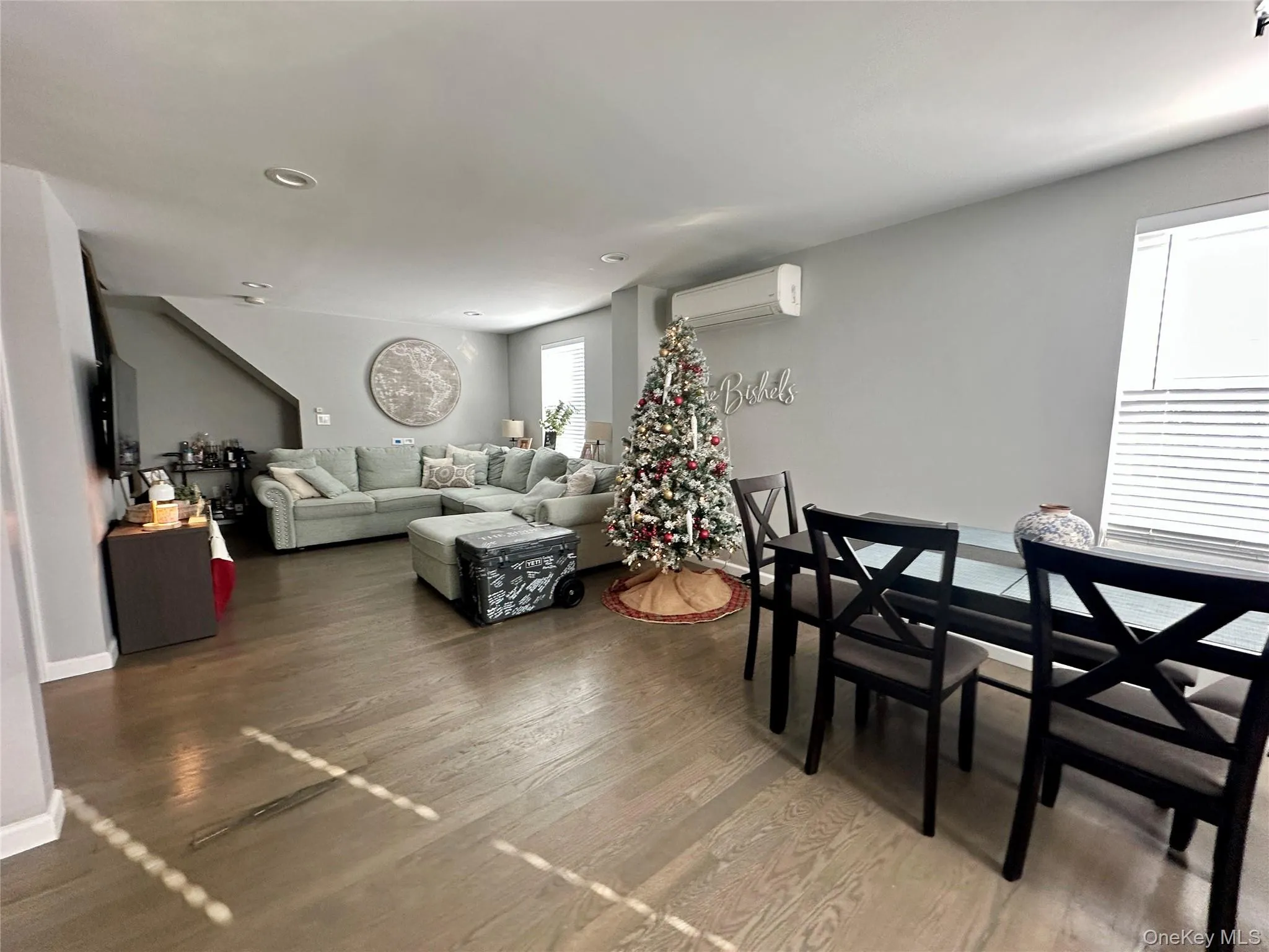 Living area with wood finished floors, a wall unit AC, and recessed lighting Living area with wood finished floors, a wall unit AC, and recessed lighting