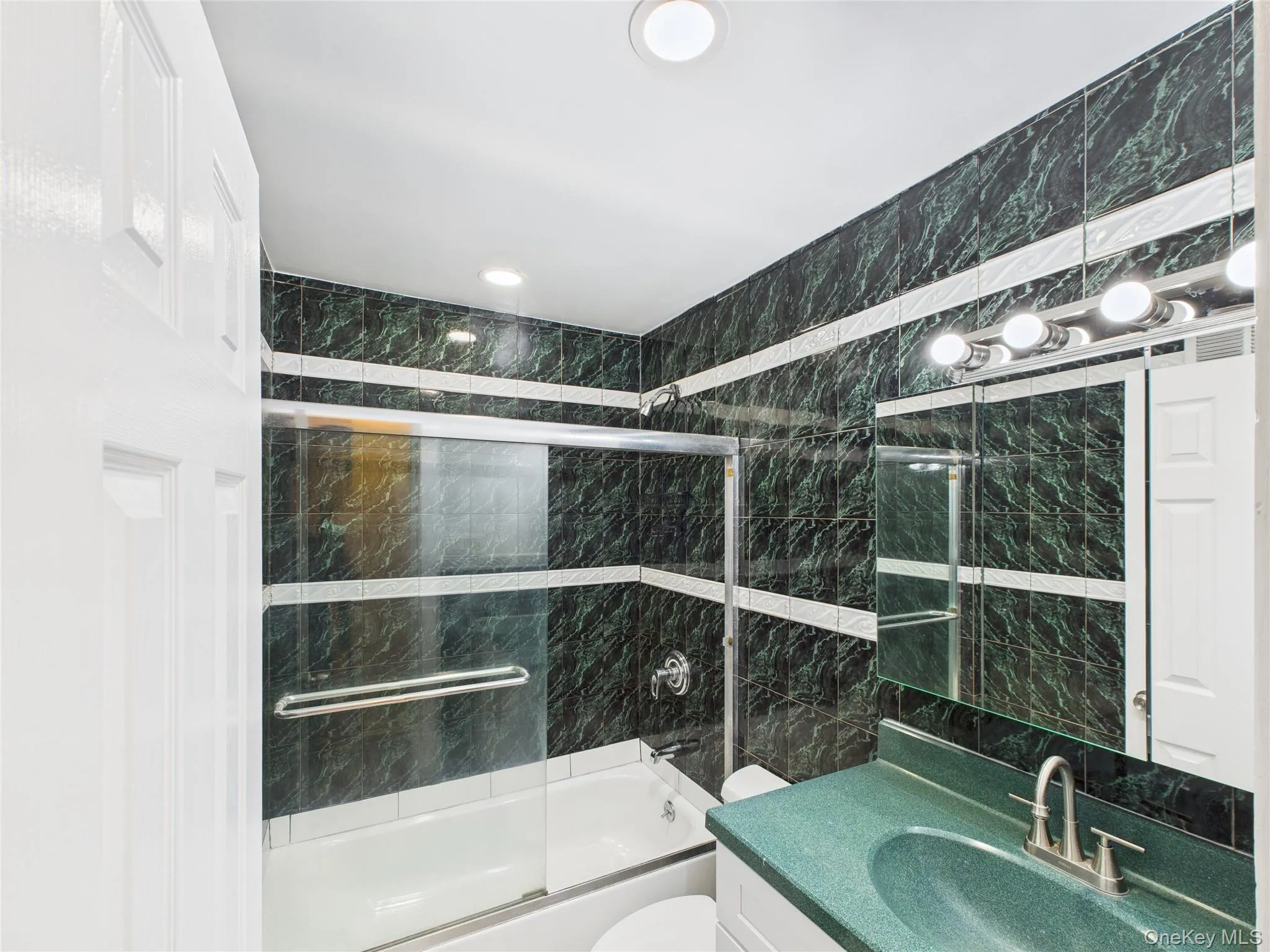 Full bath with shower / bath combination with glass door and vanity Full bath with shower / bath combination with glass door and vanity