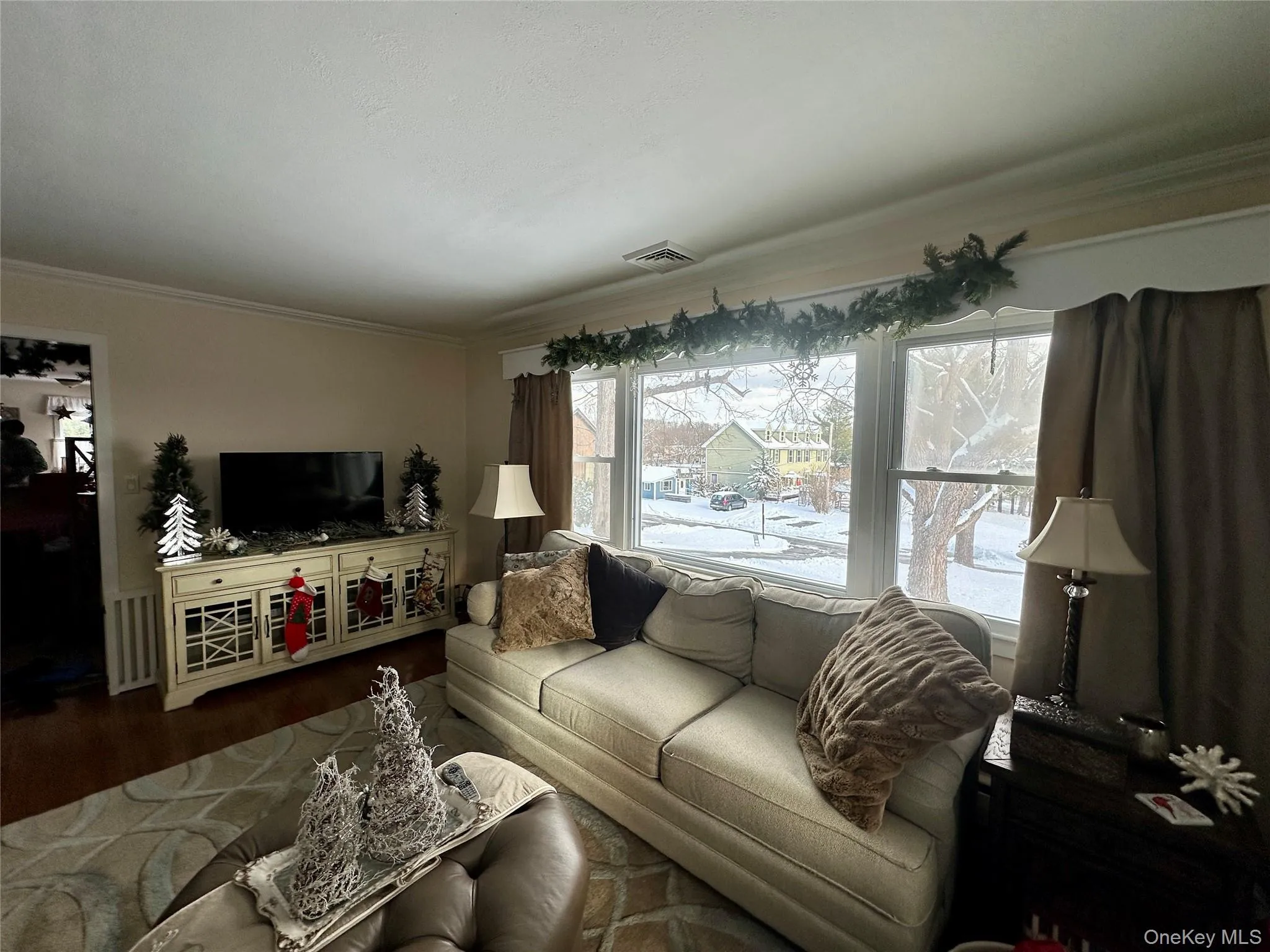 Living room featuring ornamental molding and wood finished floors Living room featuring ornamental molding and wood finished floors
