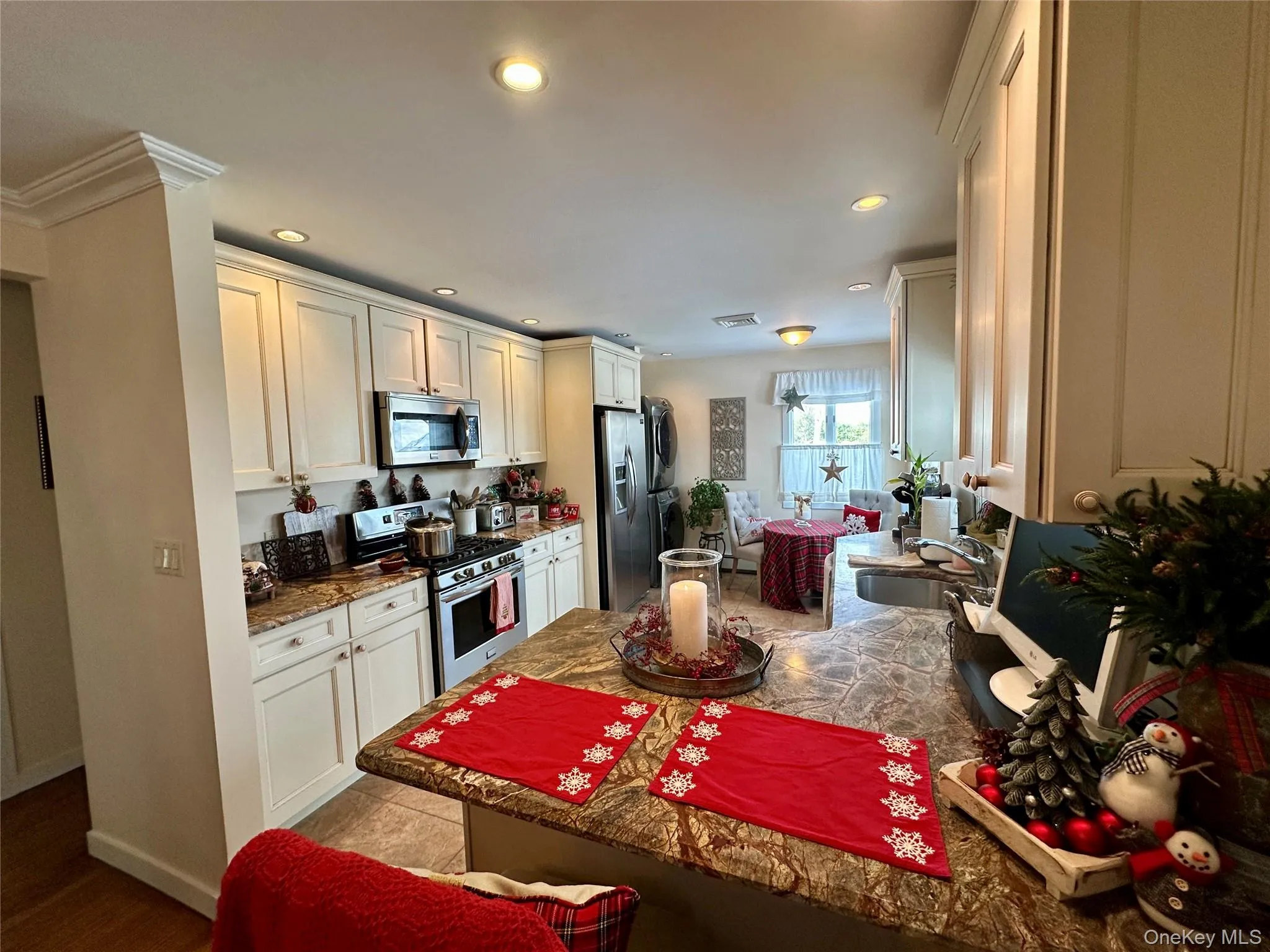 Kitchen with stainless steel appliances, recessed lighting, dark stone counters, white cabinetry, and a peninsula Kitchen with stainless steel appliances, recessed lighting, dark stone counters, white cabinetry, and a peninsula
