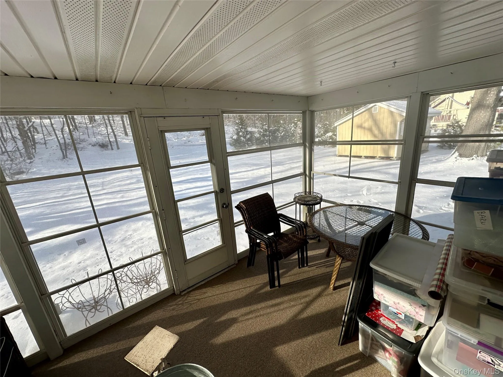 Sunroom / solarium with plenty of natural light and carpet floors Sunroom / solarium with plenty of natural light and carpet floors