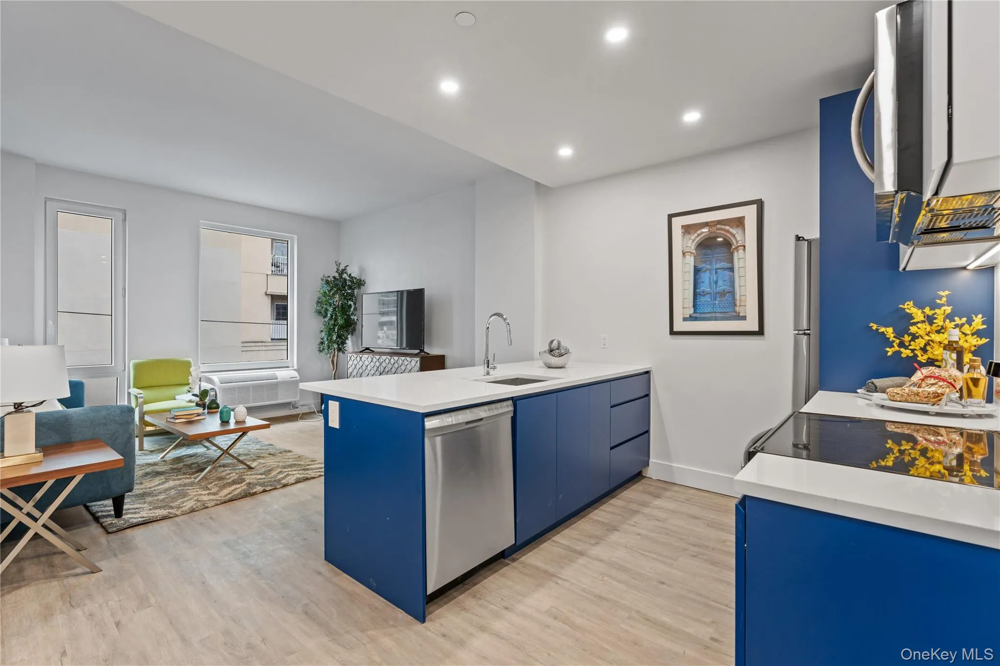 Kitchen featuring a peninsula, blue cabinetry, appliances with stainless steel finishes, recessed lighting, and light wood finished floors Kitchen featuring a peninsula, blue cabinetry, appliances with stainless steel finishes, recessed lighting, and light wood finished floors