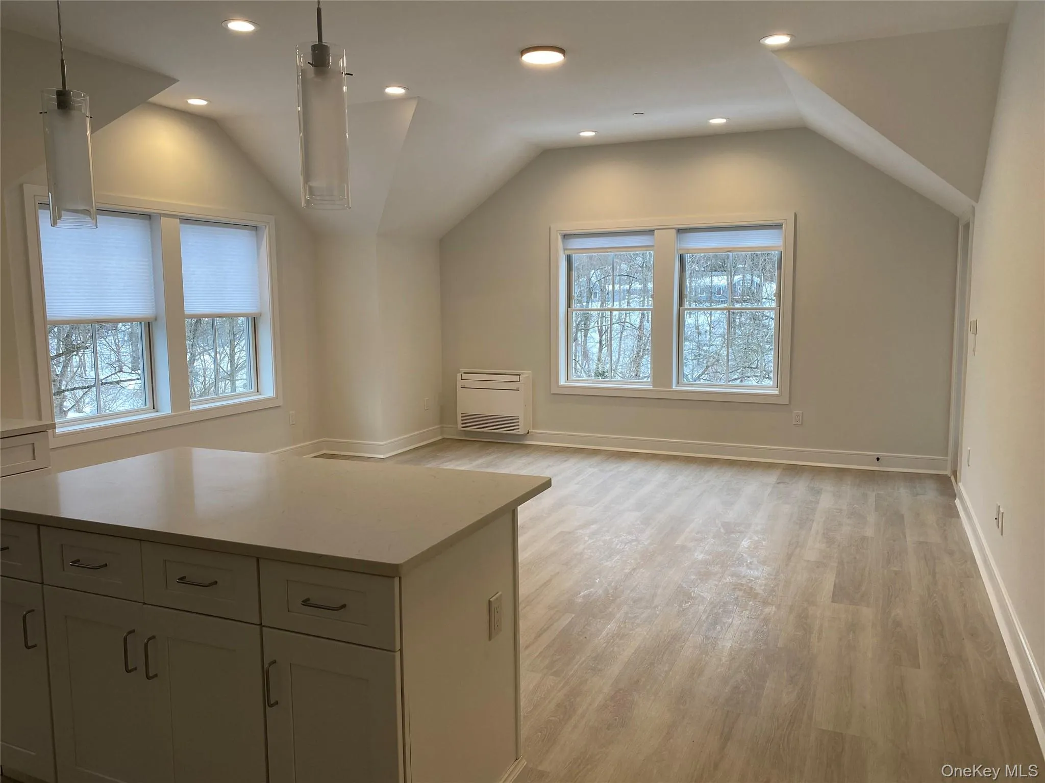 Additional living space with recessed lighting, vaulted ceiling, light wood-style flooring, and heating unit Additional living space with recessed lighting, vaulted ceiling, light wood-style flooring, and heating unit