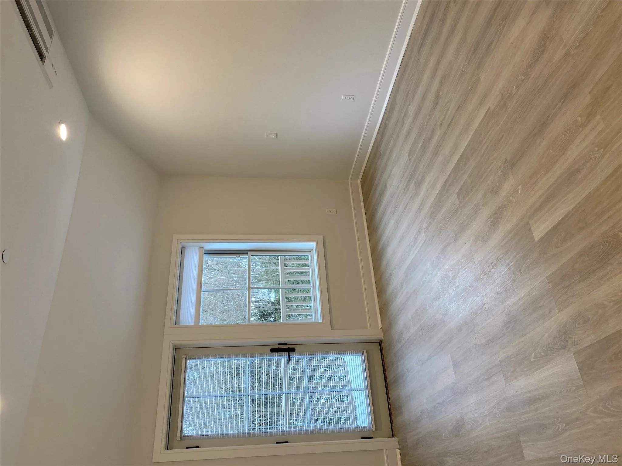 Unfurnished room with vaulted ceiling, light wood finished floors, and recessed lighting Unfurnished room with vaulted ceiling, light wood finished floors, and recessed lighting