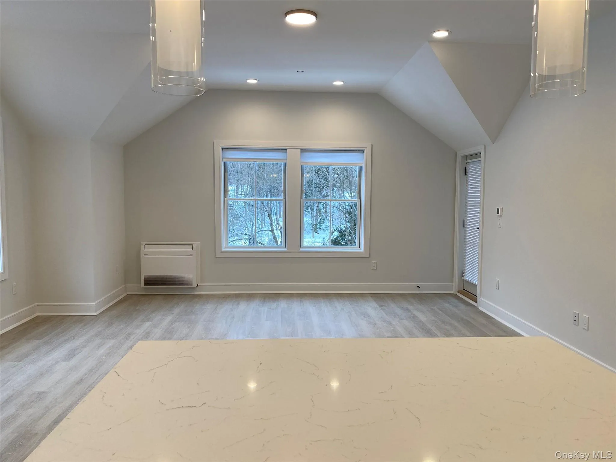 Bonus room with light wood-style flooring, healthy amount of natural light, lofted ceiling, radiator heating unit, and recessed lighting Bonus room with light wood-style flooring, healthy amount of natural light, lofted ceiling, radiator heating unit, and recessed lighting