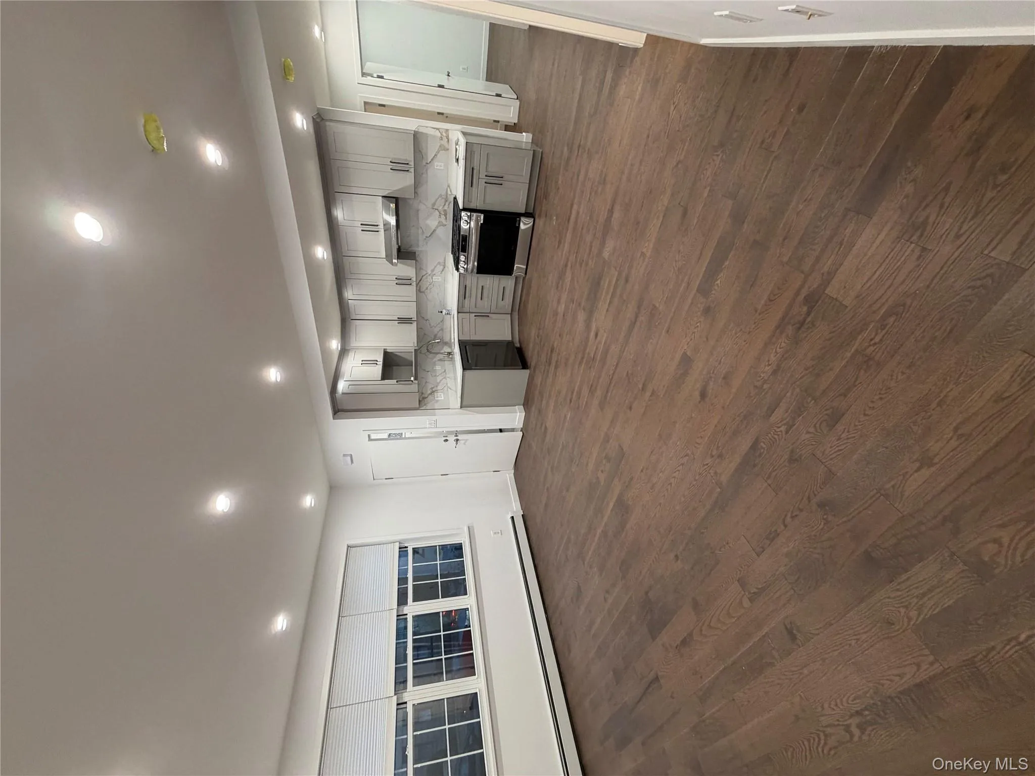 Kitchen with gray cabinets, range, a baseboard heating unit, recessed lighting, and dark wood-type flooring Kitchen with gray cabinets, range, a baseboard heating unit, recessed lighting, and dark wood-type flooring