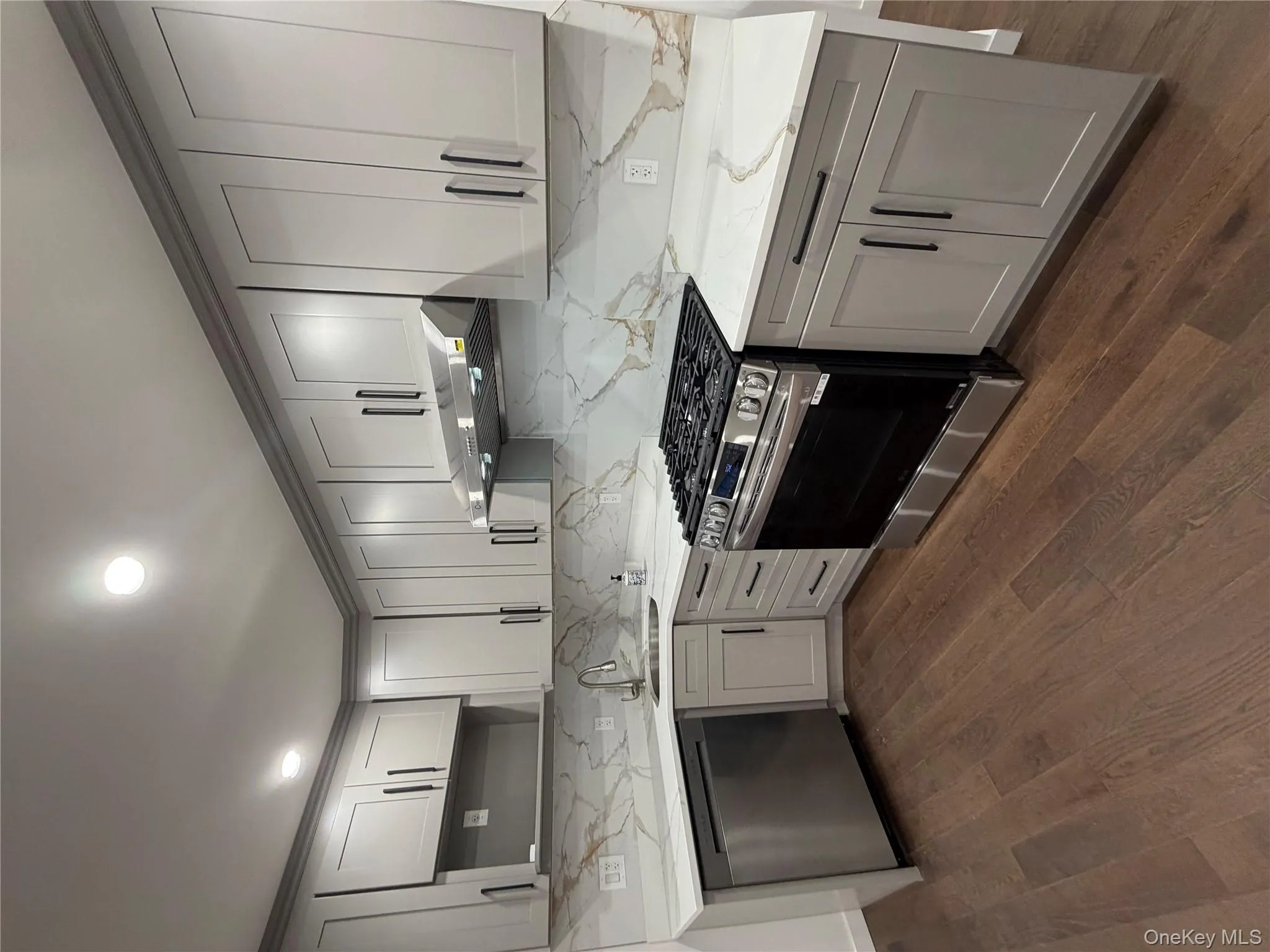 Kitchen with gray cabinetry, stainless steel range, dishwasher, light stone counters, and recessed lighting Kitchen with gray cabinetry, stainless steel range, dishwasher, light stone counters, and recessed lighting