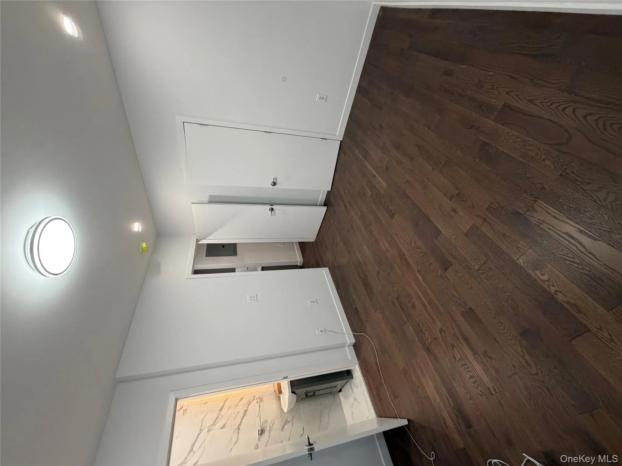 Unfurnished bedroom with dark wood-style flooring, connected bathroom, and recessed lighting Unfurnished bedroom with dark wood-style flooring, connected bathroom, and recessed lighting