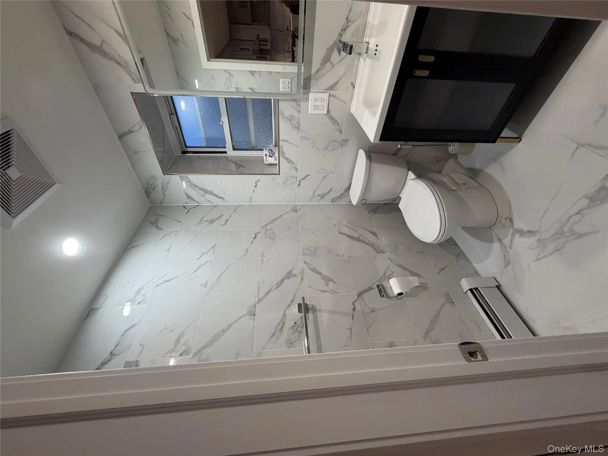 Half bathroom featuring tile walls, vanity, light marble finish flooring, baseboard heating, and recessed lighting Half bathroom featuring tile walls, vanity, light marble finish flooring, baseboard heating, and recessed lighting