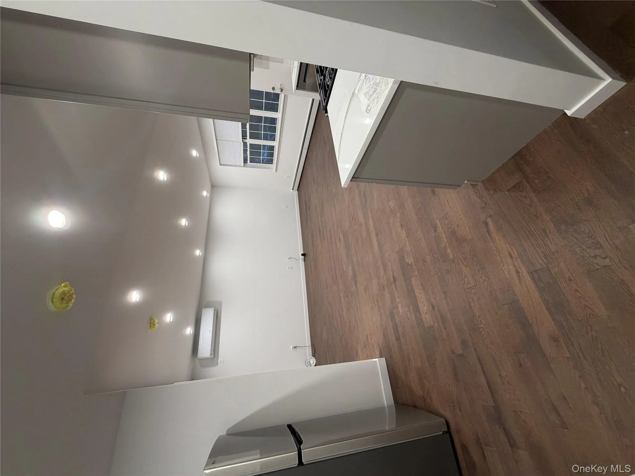 Kitchen featuring stainless steel refrigerator, recessed lighting, a baseboard heating unit, dark wood finished floors, and open floor plan Kitchen featuring stainless steel refrigerator, recessed lighting, a baseboard heating unit, dark wood finished floors, and open floor plan