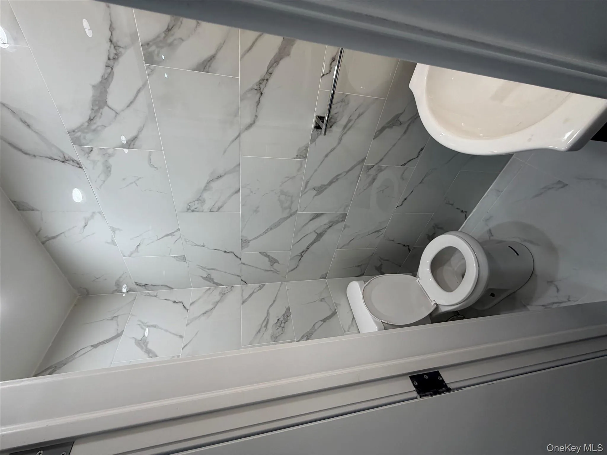 Bathroom with marble look tile flooring and toilet Bathroom with marble look tile flooring and toilet