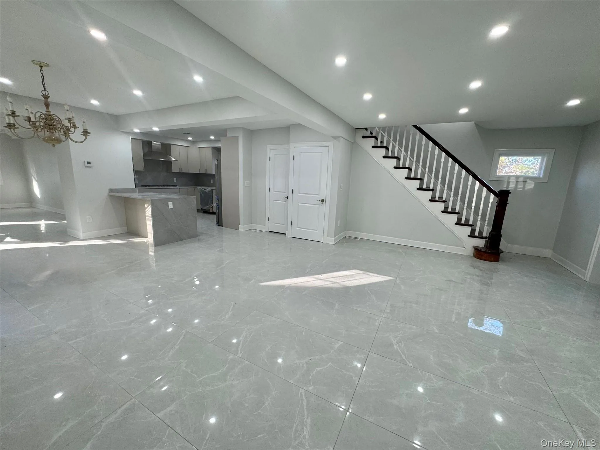 Unfurnished living room featuring light marble finish floors, stairway, a chandelier, and recessed lighting Unfurnished living room featuring light marble finish floors, stairway, a chandelier, and recessed lighting