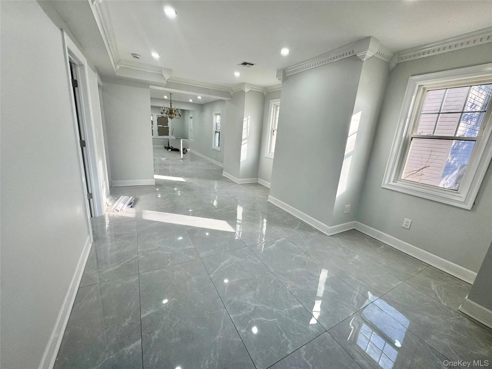 Big room with marble tiled floors, crown molding, a chandelier, and recessed lighting Big room with marble tiled floors, crown molding, a chandelier, and recessed lighting