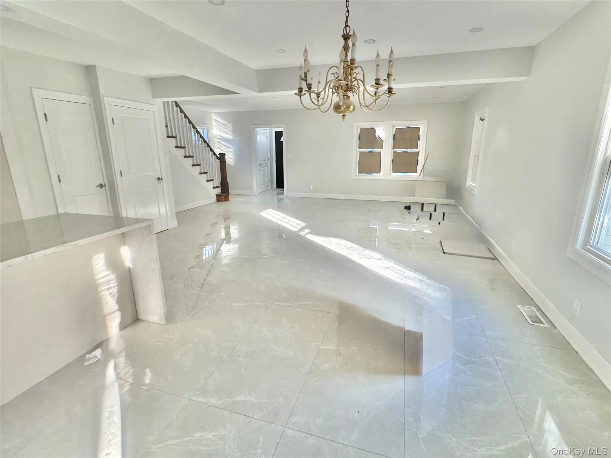 dining area featuring a chandelier, stairway, and marble tiled floors dining area featuring a chandelier, stairway, and marble tiled floors