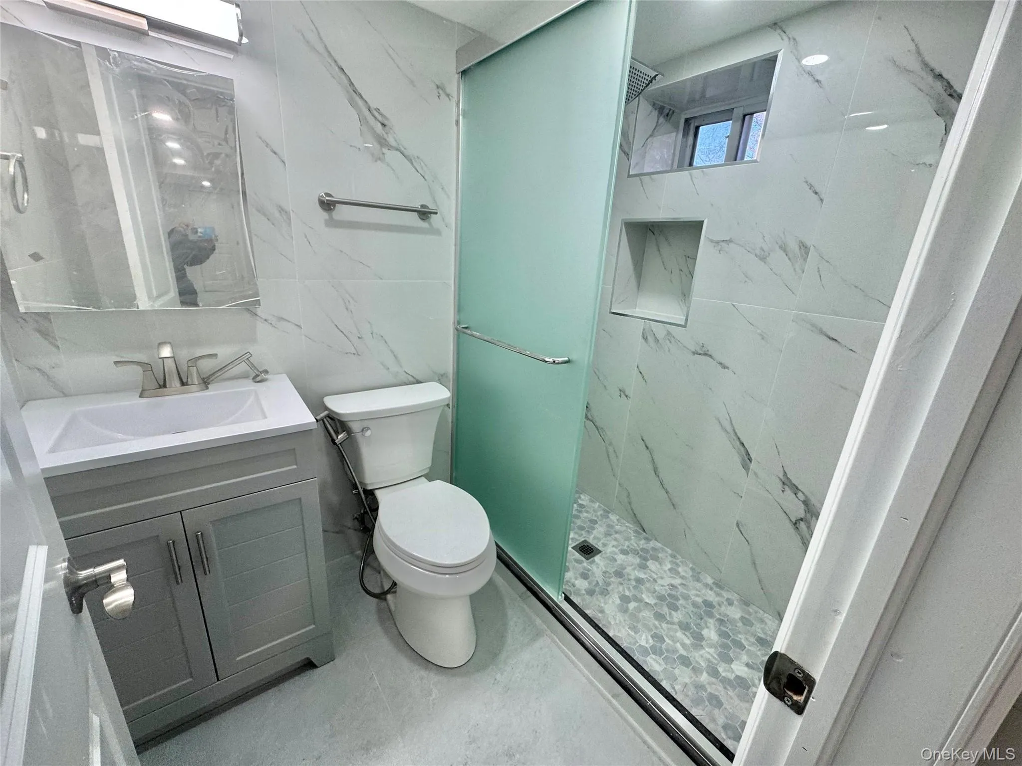 Bathroom in Basement featuring vanity, a marble finish shower, and tile walls Bathroom in Basement featuring vanity, a marble finish shower, and tile walls