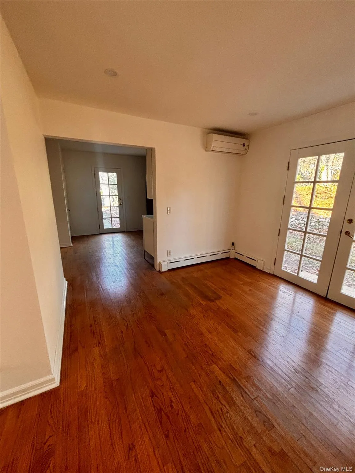 Spare room featuring wood-type flooring and a wall mounted AC Spare room featuring wood-type flooring and a wall mounted AC