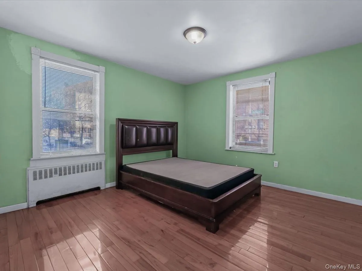 Bedroom with radiator and hardwood / wood-style flooring Bedroom with radiator and hardwood / wood-style flooring