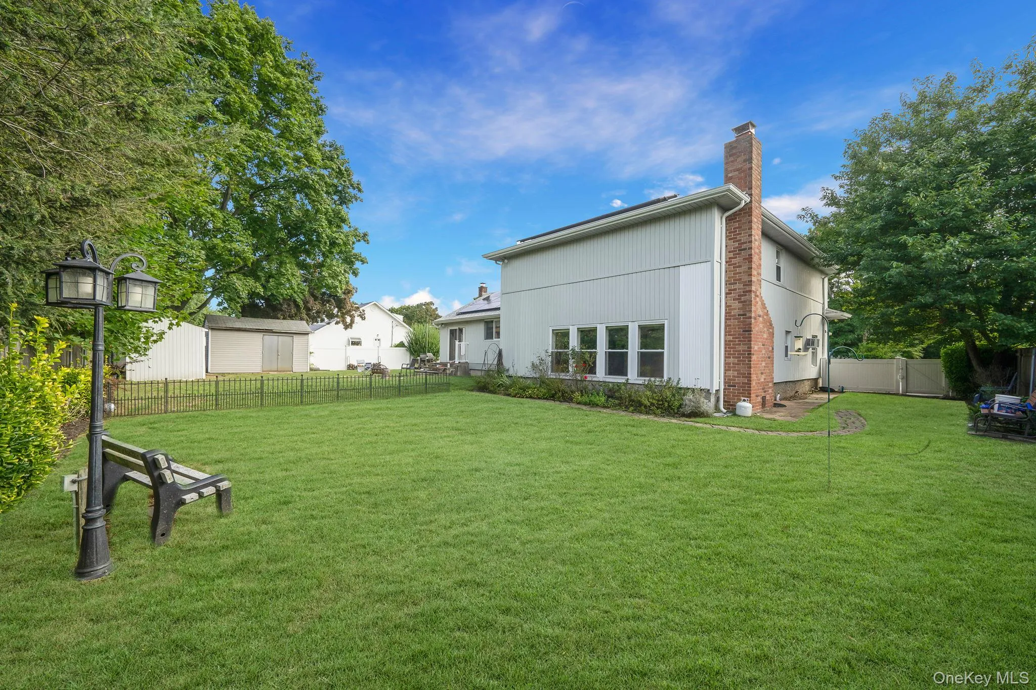 Back of property featuring a fenced backyard and a chimney Back of property featuring a fenced backyard and a chimney