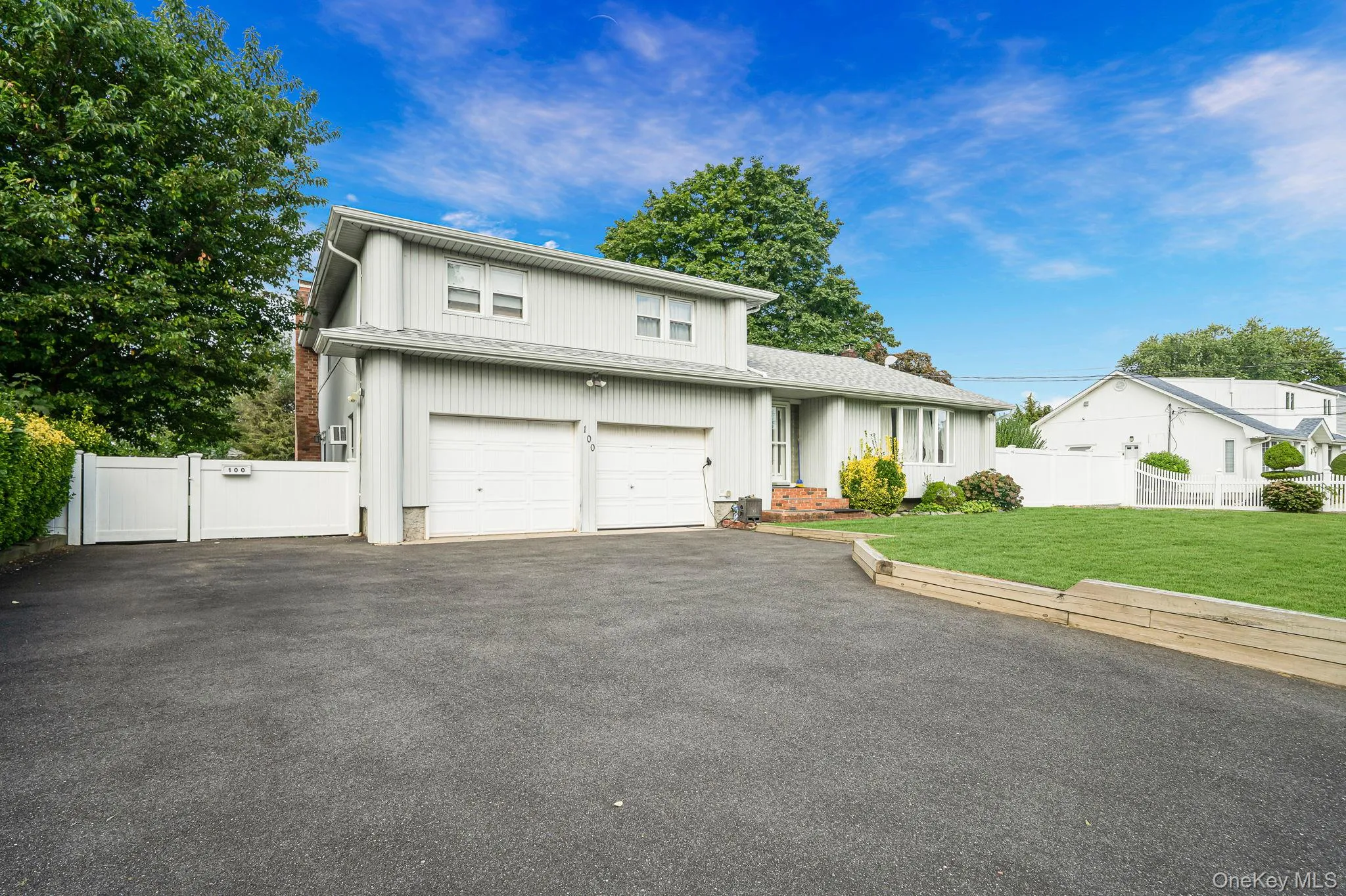 View of front facade with asphalt driveway, a garage, and a gate View of front facade with asphalt driveway, a garage, and a gate