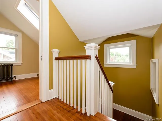 Stairs featuring wood-type flooring and radiator Stairs featuring wood-type flooring and radiator