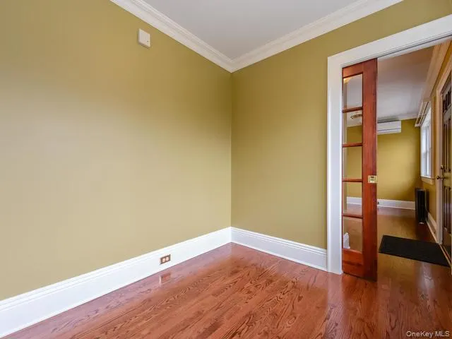 Spare room with ornamental molding and dark wood-style flooring Spare room with ornamental molding and dark wood-style flooring