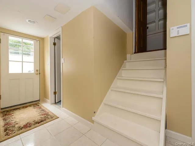 Foyer entrance featuring light tile patterned flooring and stairway Foyer entrance featuring light tile patterned flooring and stairway