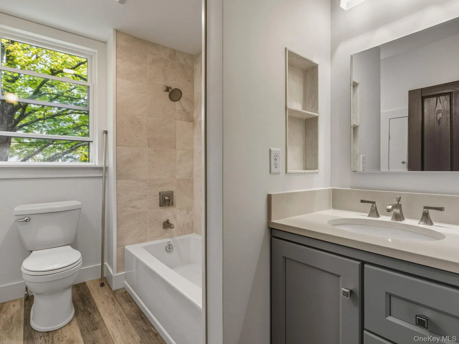Full bath with vanity, shower / washtub combination, and light wood-style flooring Full bath with vanity, shower / washtub combination, and light wood-style flooring