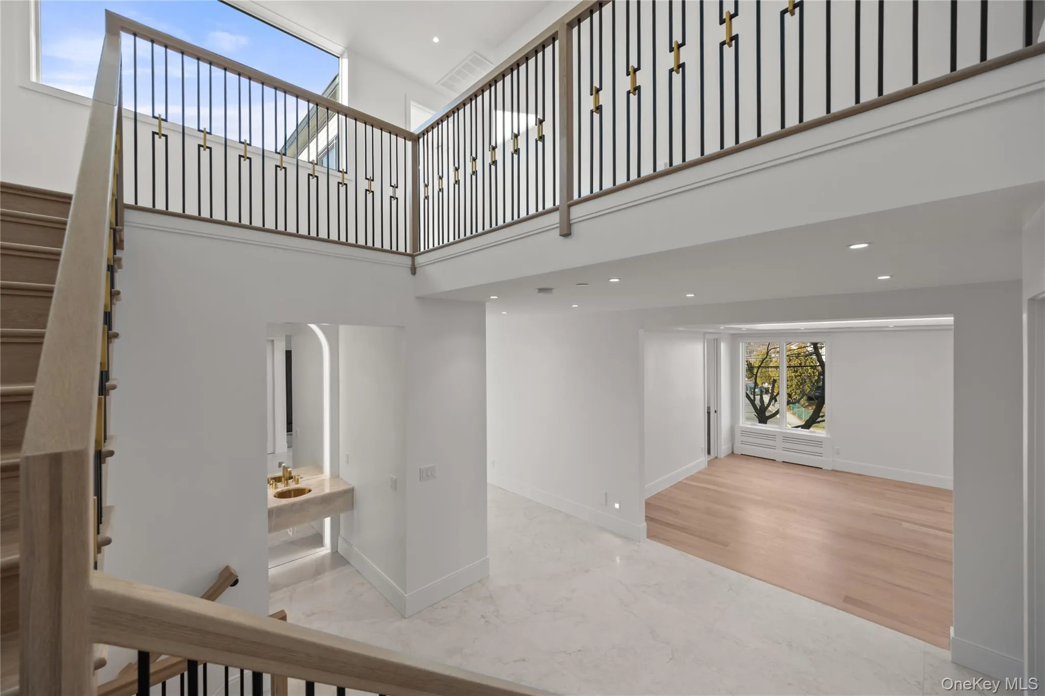 Staircase with marble tiled floors, a high ceiling, and Designer Spindle Stair Railings Staircase with marble tiled floors, a high ceiling, and Designer Spindle Stair Railings