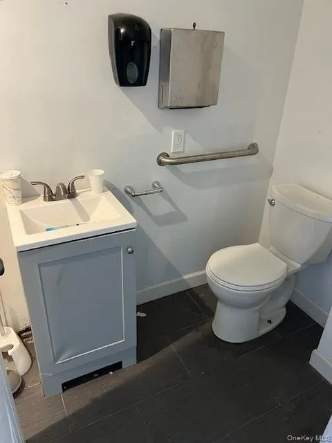 Half bath featuring vanity and baseboards Half bath featuring vanity and baseboards