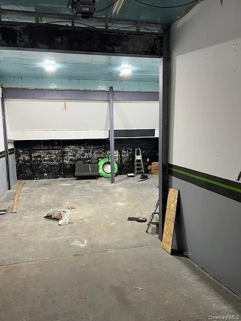 Misc room featuring a garage and unfinished concrete flooring Misc room featuring a garage and unfinished concrete flooring