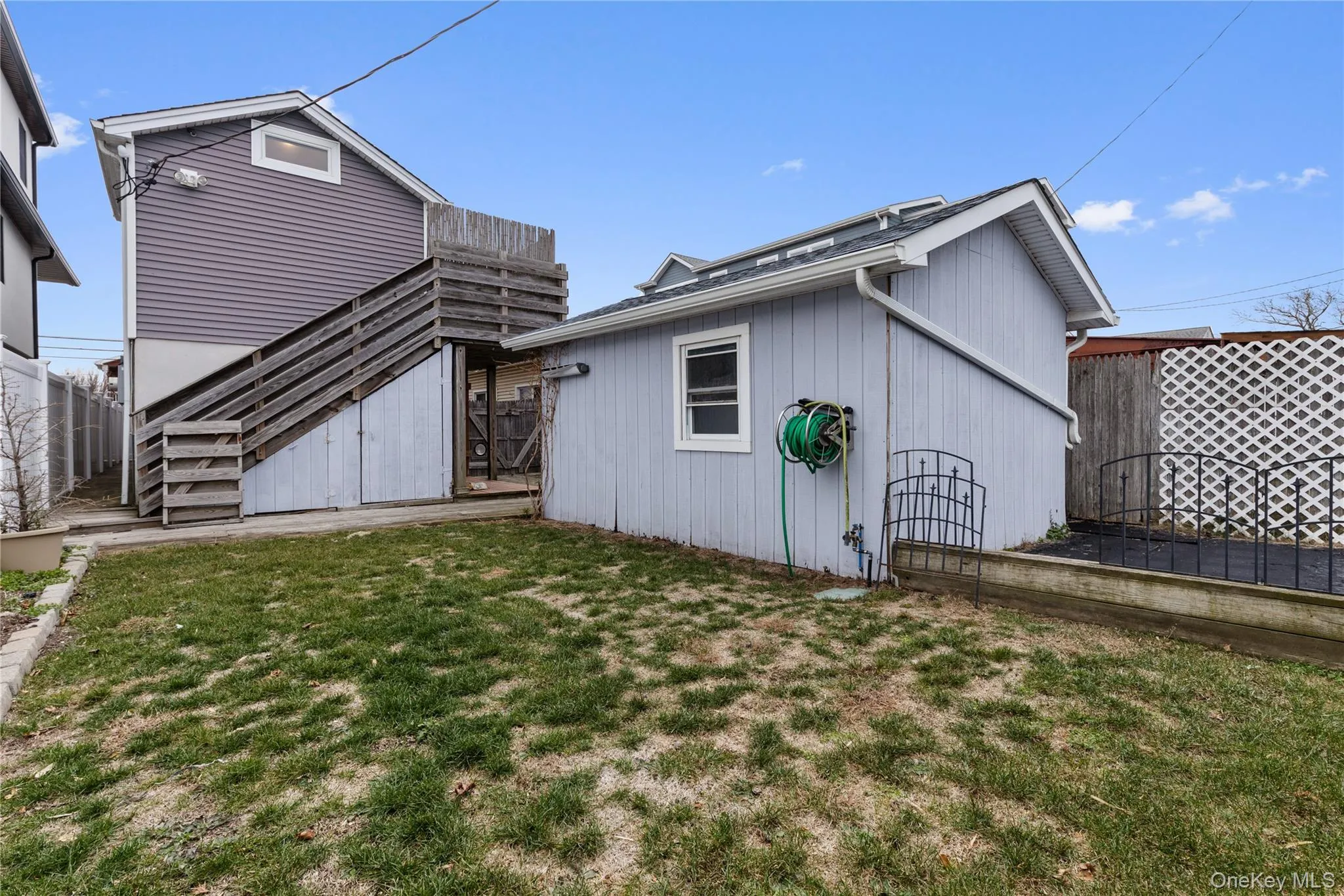 Rear view of house featuring stairs and a gate Rear view of house featuring stairs and a gate