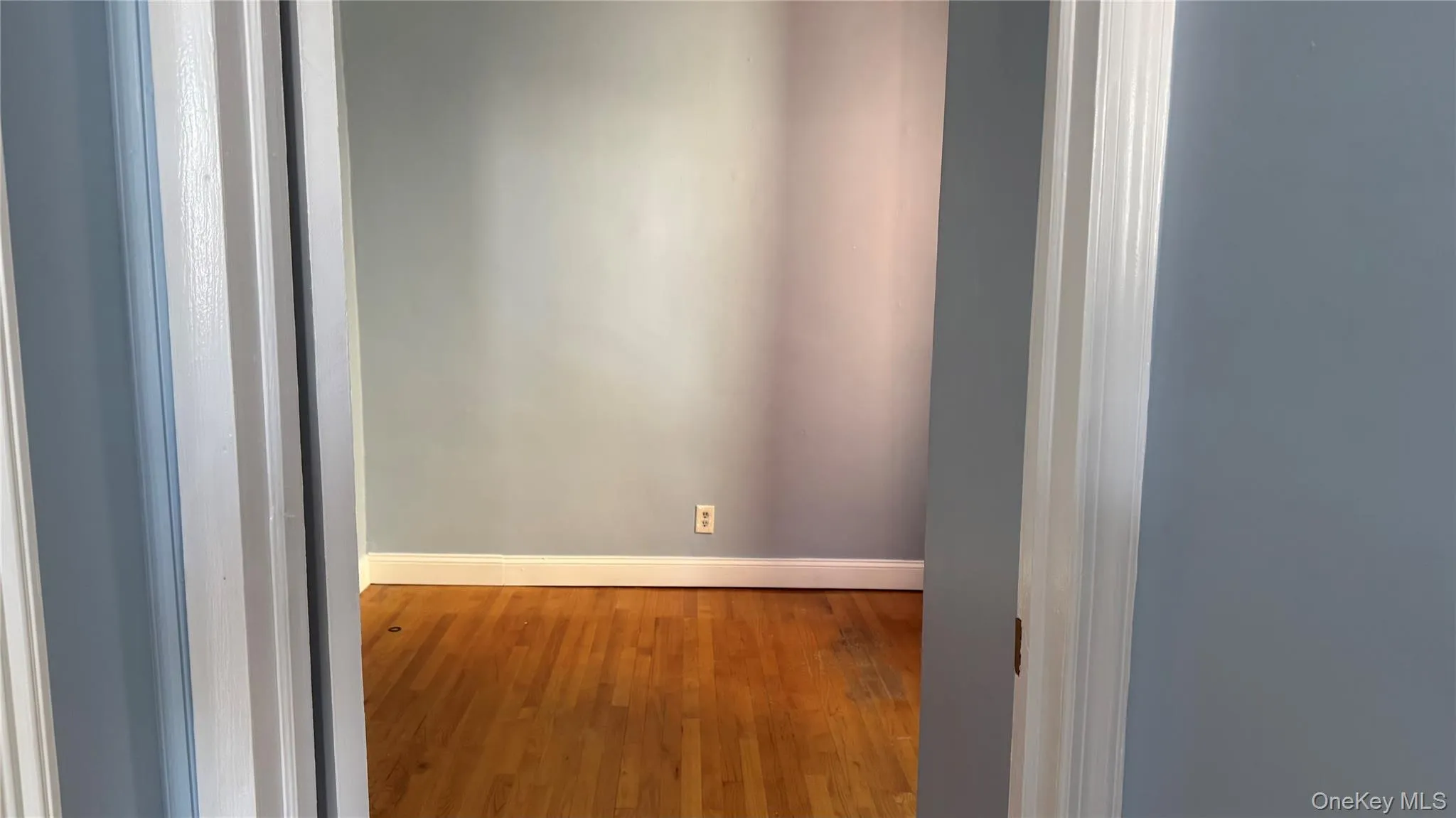 Unfurnished room featuring wood-type flooring and baseboards Unfurnished room featuring wood-type flooring and baseboards