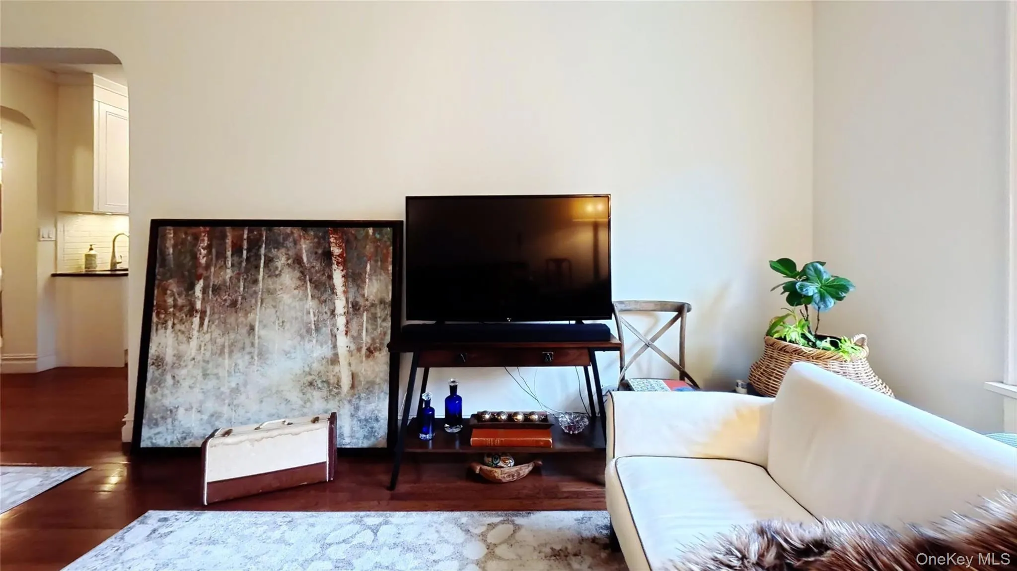 Living area with arched walkways and wood finished floors Living area with arched walkways and wood finished floors