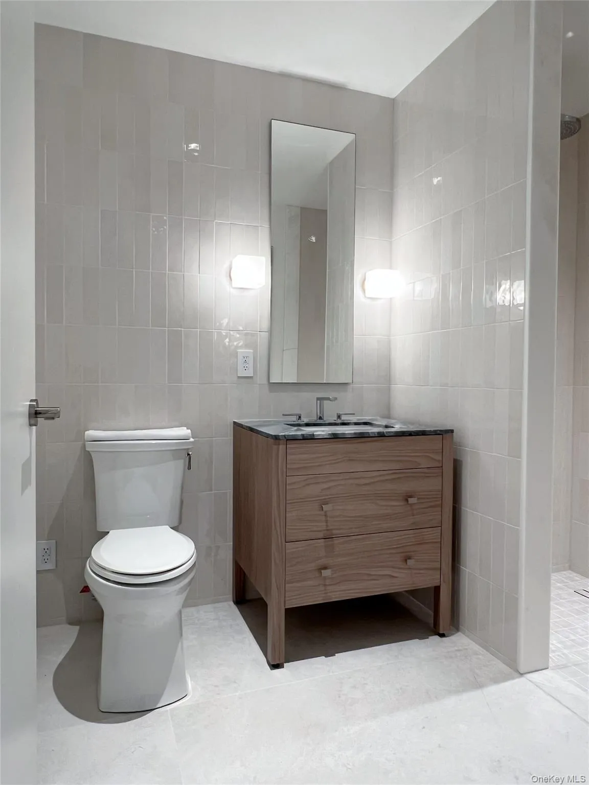 Full bathroom with tile walls, vanity, and a tile shower Full bathroom with tile walls, vanity, and a tile shower
