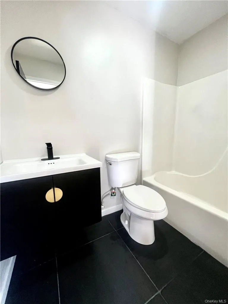 Full bathroom with toilet, vanity, shower / tub combination, and tile patterned floors Full bathroom with toilet, vanity, shower / tub combination, and tile patterned floors