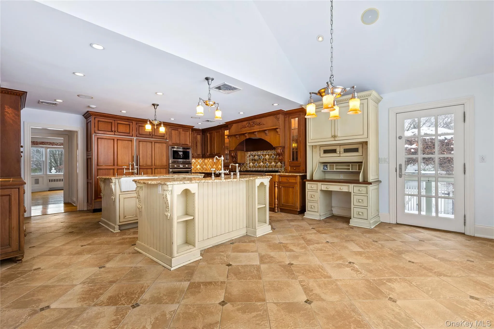Alternative view of kitchen with two-tone cabinetry, and side door out to terrace Alternative view of kitchen with two-tone cabinetry, and side door out to terrace