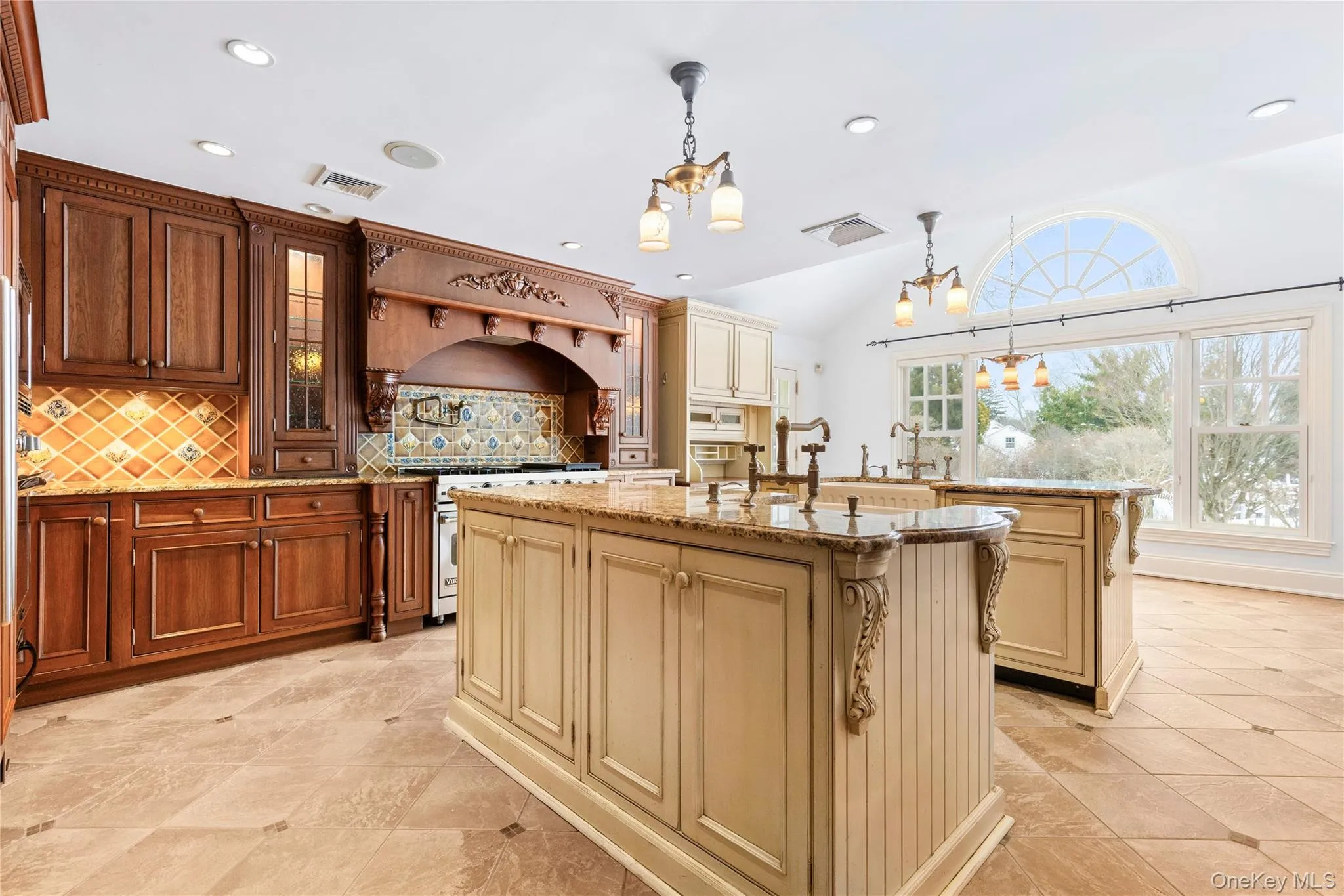 Spacious kitchen features two islands, custom cabinetry & bright dining area with cathedral ceilings in rear Spacious kitchen features two islands, custom cabinetry & bright dining area with cathedral ceilings in rear
