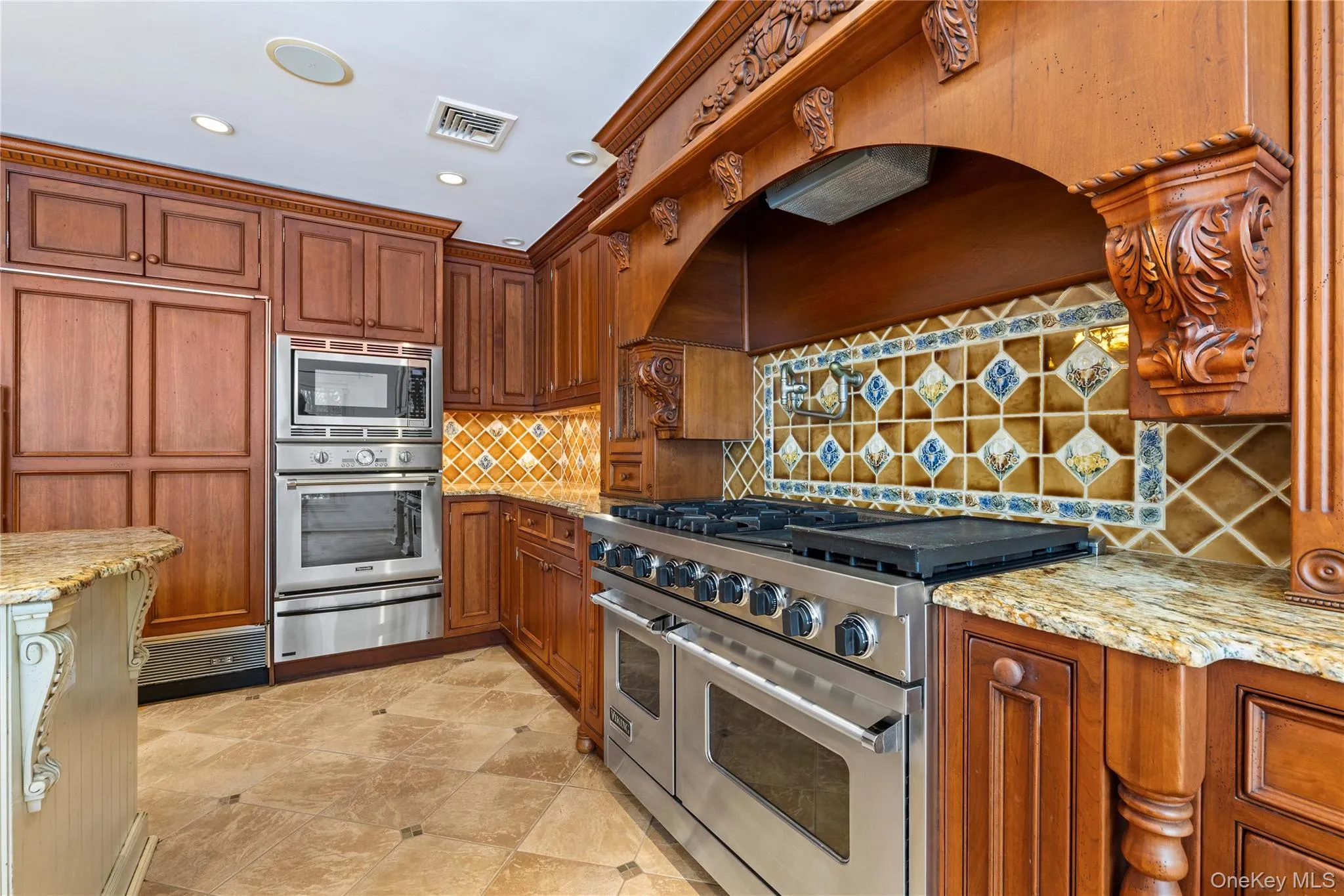 Elevated kitchen features appliances with stainless steel finishes, a warming drawer, and decorative backsplash - includes a mounted water fill pipe Elevated kitchen features appliances with stainless steel finishes, a warming drawer, and decorative backsplash - includes a mounted water fill pipe