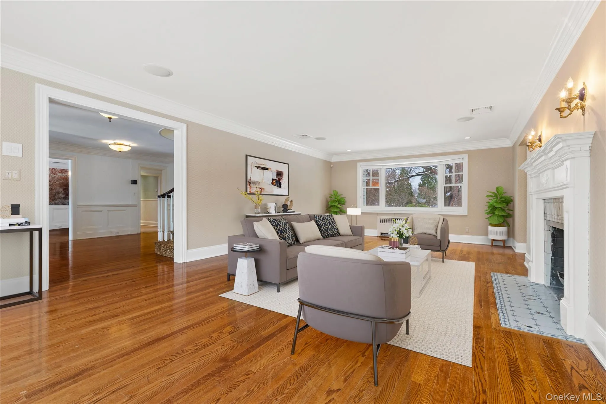 Digitally Staged: Oversized living room features a fireplace with flush hearth, and ornamental molding Digitally Staged: Oversized living room features a fireplace with flush hearth, and ornamental molding