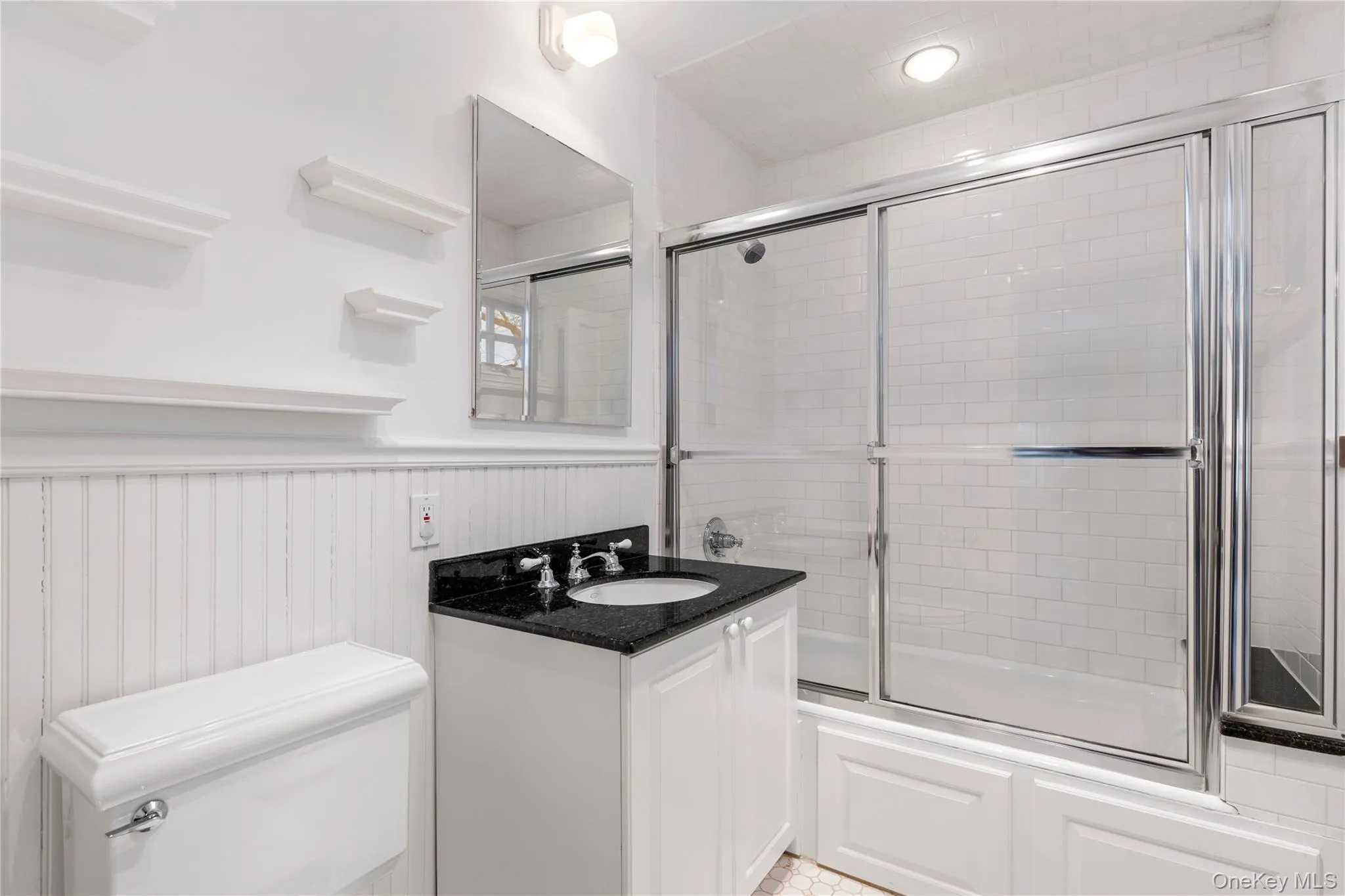 En-suite bathroom includes wainscoting and enclosed tub/shower combination En-suite bathroom includes wainscoting and enclosed tub/shower combination