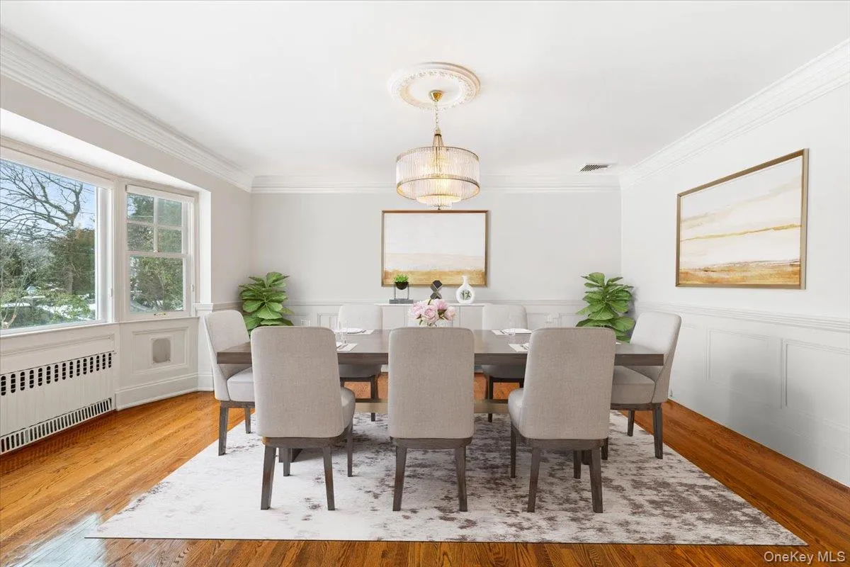 Digitally Staged: Dining room includes large bay windows, crown molding and elegant wall paneling Digitally Staged: Dining room includes large bay windows, crown molding and elegant wall paneling