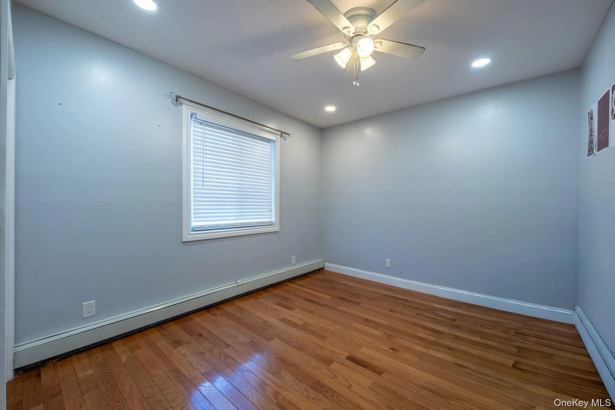Spare room with a baseboard heating unit, hardwood / wood-style floors, recessed lighting, and a ceiling fan Spare room with a baseboard heating unit, hardwood / wood-style floors, recessed lighting, and a ceiling fan