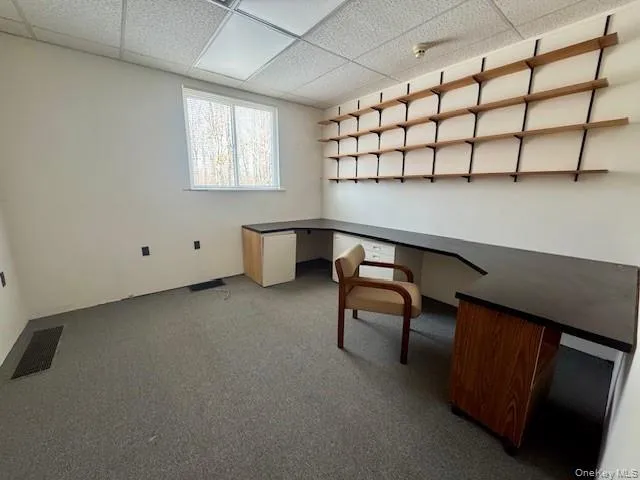 Unfurnished office with a drop ceiling and carpet flooring Unfurnished office with a drop ceiling and carpet flooring