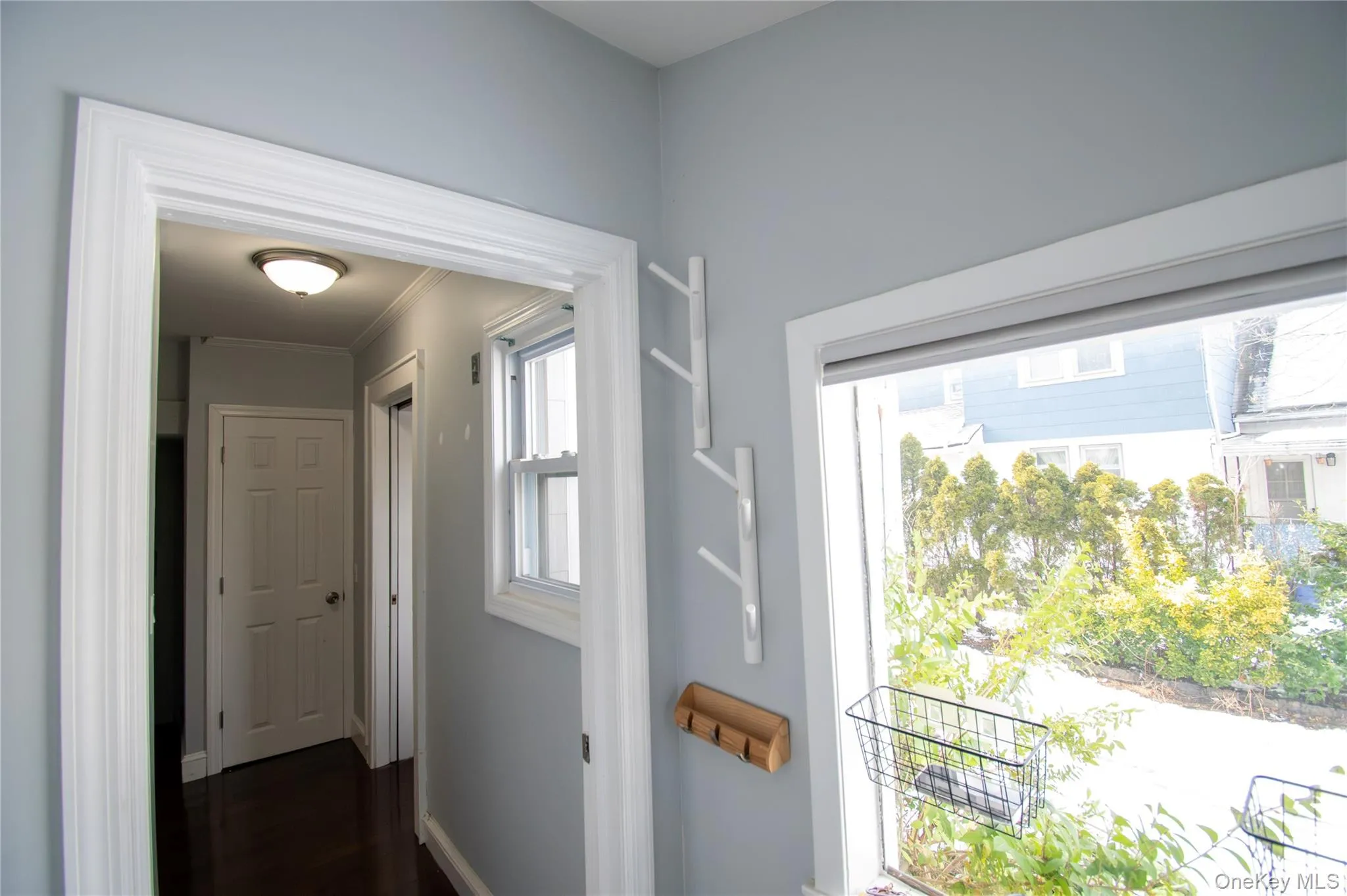 Hallway featuring ornamental molding and dark wood-type flooring Hallway featuring ornamental molding and dark wood-type flooring
