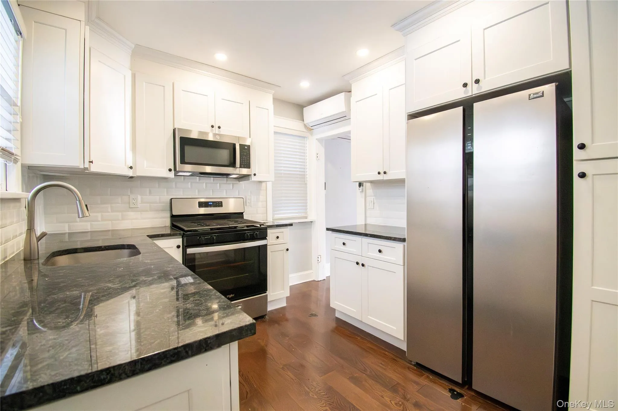Kitchen with stainless steel appliances, dark stone counters, white cabinetry, and recessed lighting Kitchen with stainless steel appliances, dark stone counters, white cabinetry, and recessed lighting